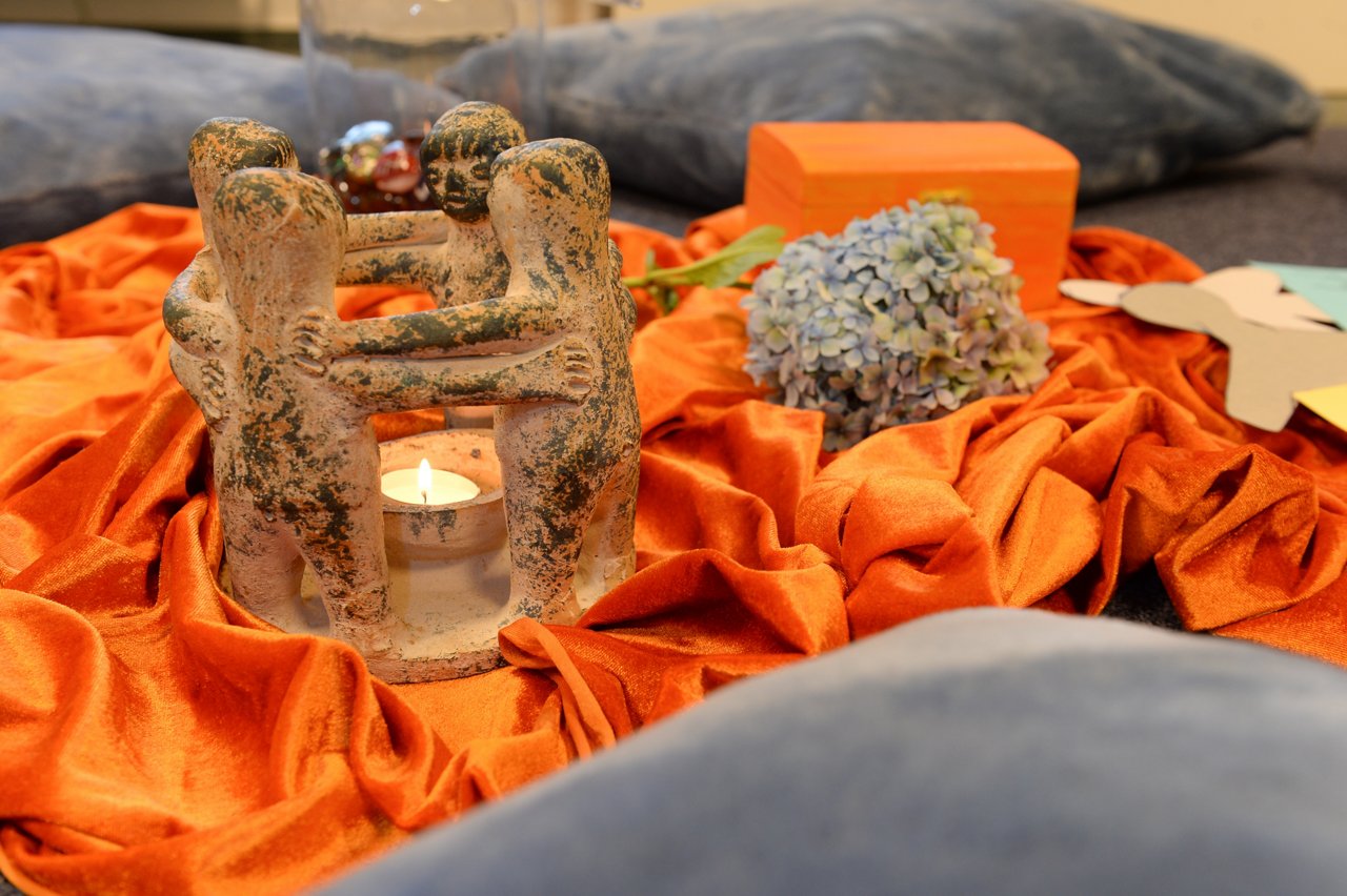 Tonkreis Teelicht auf orangenem Stoff Palliativmedizin