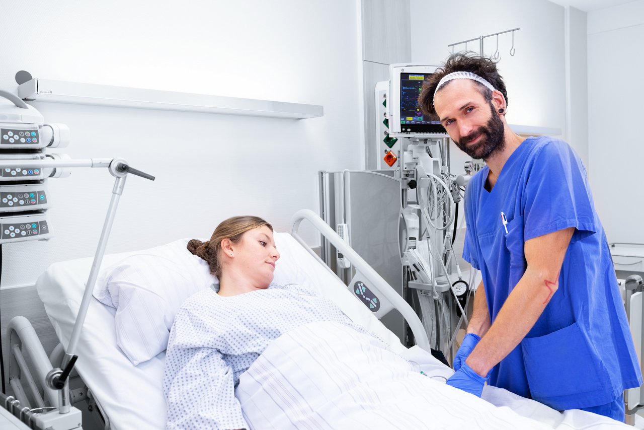 Eine Intensiv-Pflegekraft steht am Patientenbett.