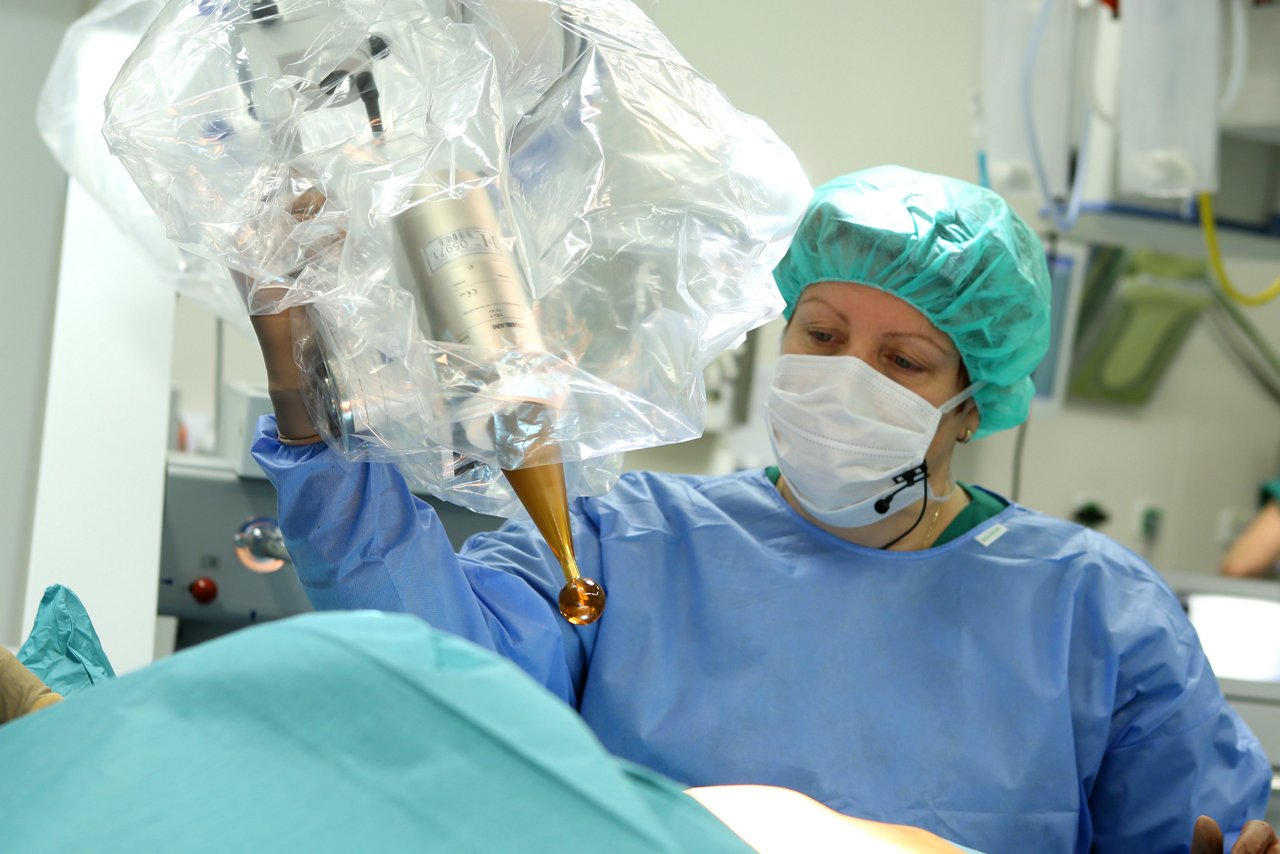 Medizinerin führt Bestrahlungsapplikator zum Oberkörper einer Patientin