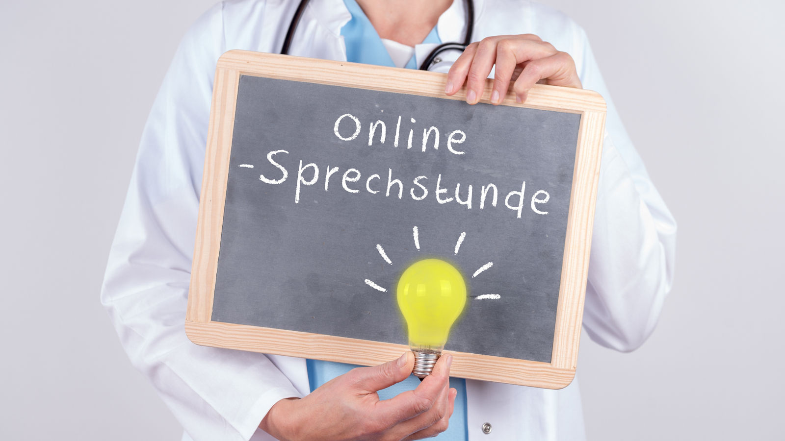 Arzt mit Schild auf dem Online Sprechstunde steht