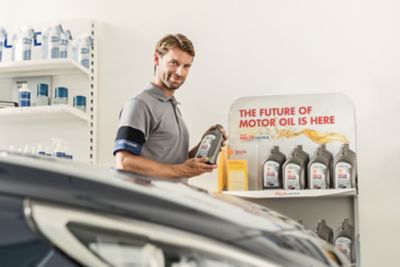 Pracownik serwisu Hyundai prezentuje oleje silnikowe Shell.