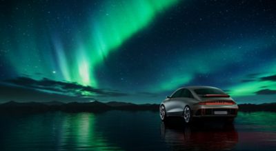 The Hyundai all-electric IONIQ 6 Streamliner from the rear with northern lights in the background.