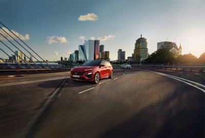 The Hyundai KONA N Line entering a bridge with skyline in the background.