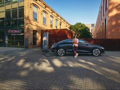 Hyundai IONIQ 6, štvordverový elektrický sedan nabíjajúci sa na ulici.