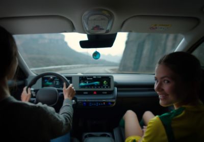 Mężczyzna i uśmiechnięta kobieta siedzą wewnątrz modelu Hyundai IONIQ 5.