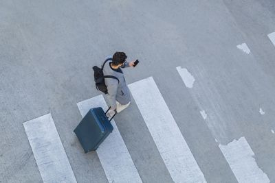 Persona apoyada en la pared de una oficina sonríe.