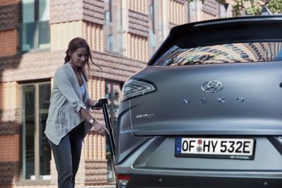 Une femme rechargeant la pile à combustible de la Hyundai NEXO.