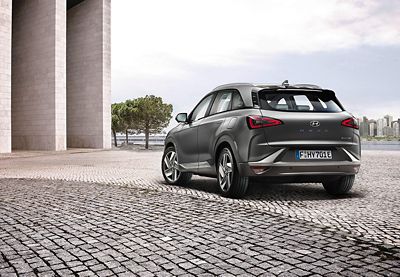 Hyundai Nexo zaparkowany na tle miejskiej panoramy. 