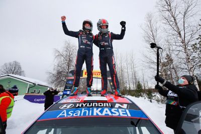 Hyundai Motorsport driver Ott Tänak and co-driver Martin Järveoja standing on the Hyundai i20 Coupe WRC, celebrating their win. 