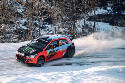 Voiture de rallye Hyundai Motorsport i20 driftant dans la neige.