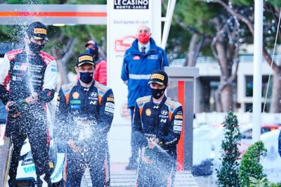 Hyundai Motorsport driver Thierry Neuville & co-driver Martijn Wydaeghe spraying champaign.