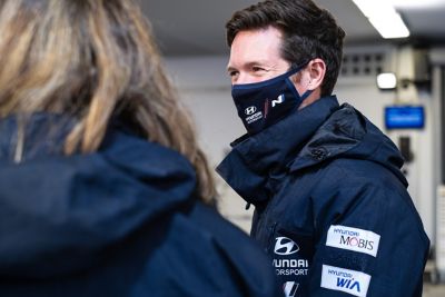 Hyundai Motorsport co-driver Martijn Wydaeghe smiling at crew members with mask.