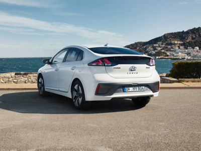 The Hyundai IONIQ Hybrid parked on a waterside from the rear.