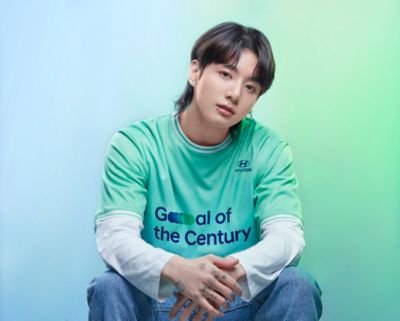 BTS member Jung Kook wearing a  Hyundai Team Century shirt with Goal of the Century on the front.	