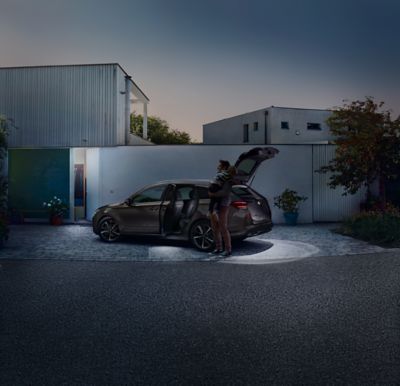 The Hyundai i30 Wagon LED trunk and tailgate lights parked next to a house in the dark.