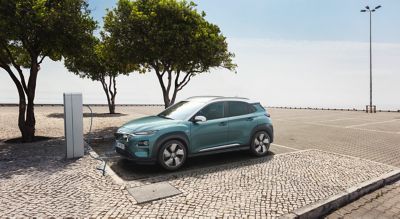 Hyundai IONIQ connectée à une wallbox sur un mur extérieur.