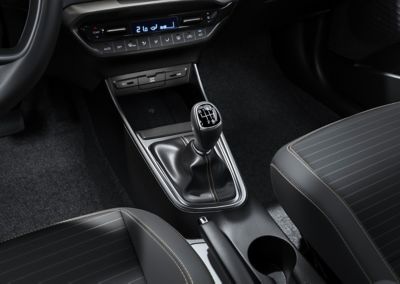 Una palanca de cambios de transmisión manual dentro de un nuevo Hyundai i20, vista del lado del pasajero