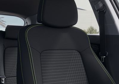 Pohled zblízka na sedadlo řidiče nového vozu Hyundai i20, barevné schéma Lime Green.