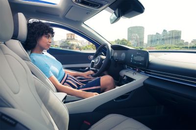 Kobieta siedząca za kierownicą Nowego Hyundaia Elantra.