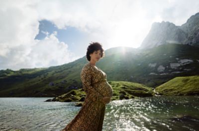 Donna incinta davanti a paesaggio naturale