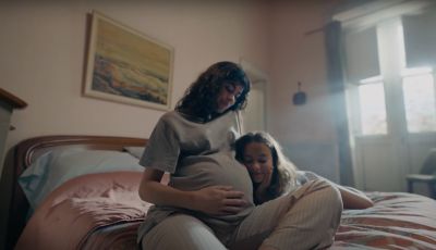 Donna incinta con bambina accanto nel letto