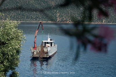 A small ship recovers discarded nets from the ocean floor in Ithaka, Greece