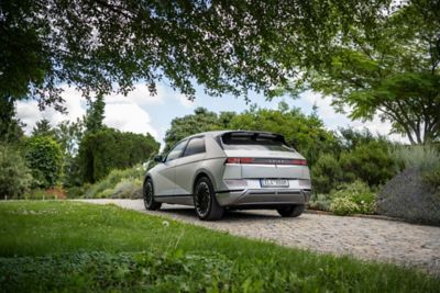 Žena stojící u modelu IONIQ 5 v kempu