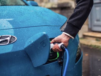 The Hyundai KONA Electric charging safely in the rain thanks to its humidity protection.