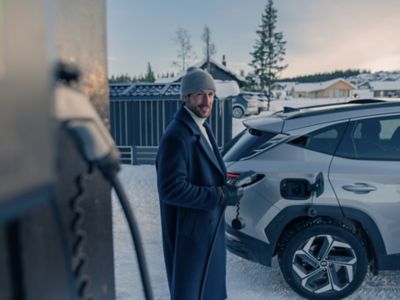 Řidič elektromobilu Hyundai se připravuje na nabíjení svého vozu pomocí wallboxu.