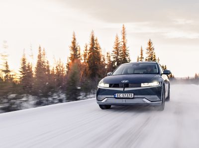 The Hyundai IONIQ 5 Electric driving safely through snow and cold weather.
