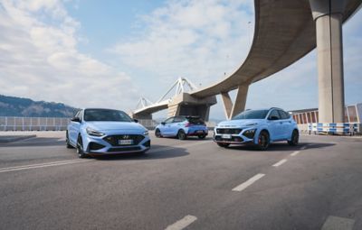 Vista frontale di Nuova Hyundai i30 N in Performance Blu parcheggiata accanto a un edificio industriale
