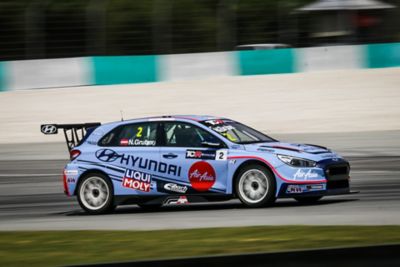  A picture of Hyundai Motorsport’s i30 N TCR in action on a racetrack shown from the side.