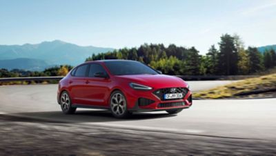 The new Hyundai i30 N racing a corner in the colour Engine Red.