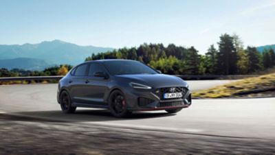 The Hyundai i30 N racing a corner in the colour Dark Knight Pearl.