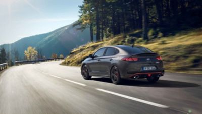 the new Hyundai i30 Fastback N approaching a curve on a mountain road