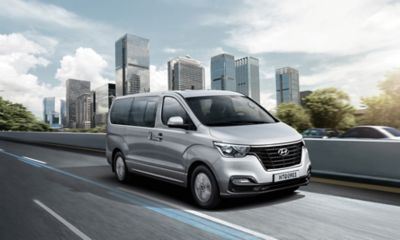 The Hyundai H-1 driving on a highway in silver.