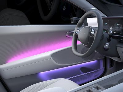Blick in das Interieur eines Hyundai IONIQ 6 mit Ambiente-Innenbeleuchtung. 