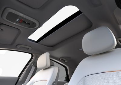 Vnútorný pohľad na veľké strešné okno Hyundai IONIQ 6, ktoré sa otvára stlačením tlačidla.