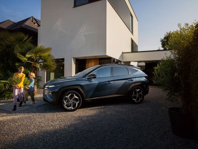 The Hyundai Tucson Hybrid compact SUV parked in a driveway.