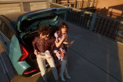 Couple sitting in the boot of the Hyundai BAYON compact crossover SUV