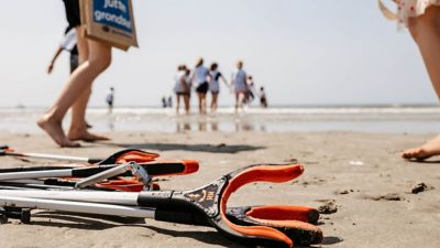 Gripearmer for plukking av plastsøppel ligger klare på stranden. Foto.