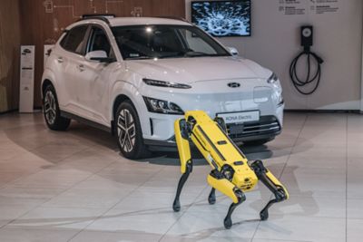 Robot Spot di Boston Dynamics di fronte a Hyundai KONA Electric