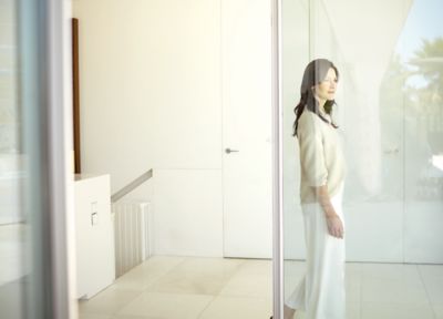 A woman standing in a white room and helped by Hyundai during COVID-19.