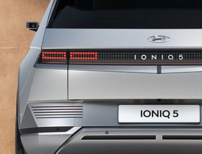 CUV compact électrique Hyundai IONIQ 5 avec son design futuriste et ses feux arrière allumés.