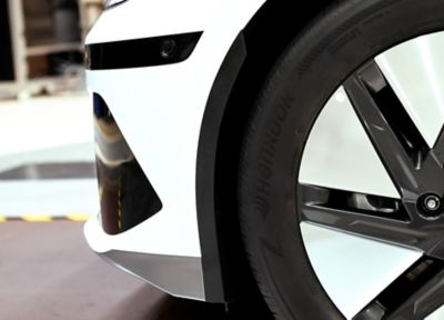 Redusert hjulbueåpning foran hjulet på en hvit Hyundai IONIQ 6. Foto.