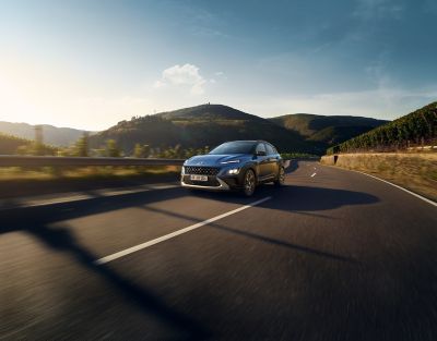 KONA Hybrid driving on a curvy street.