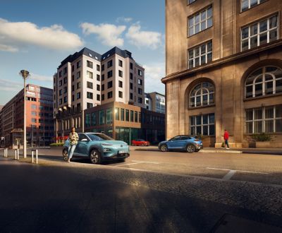 Vista laterale del SUV Nuova Hyundai KONA Hybrid parcheggiato su una strada della città.