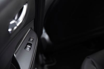 Close-up van de raamschakelaar en de knop voor de zetelverwarming in de Hyundai KONA.