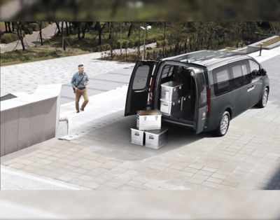 The all-new STARIA Van pictured with open twin doors and boxes as cargo.