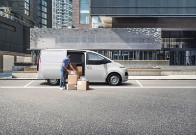 The all-new STARIA Van parked at a curb, delivery guy unpacking from the side door.